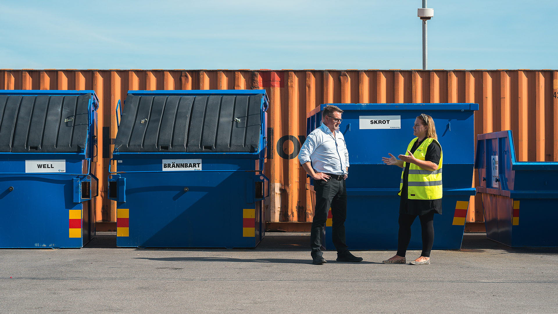 Företagskund och säljare från Tekniska verken pratar framför kundens sorteringscontainrar