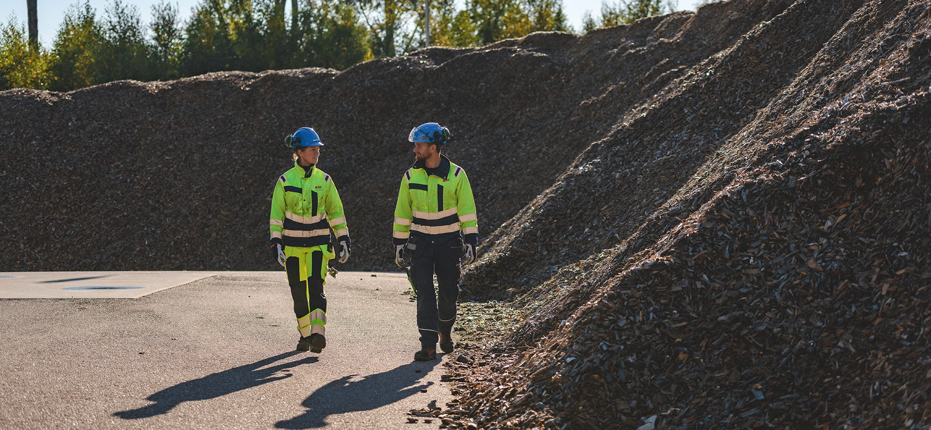 Medarbetare gåt vid flishög på kraftvärmeverket i Mjölby