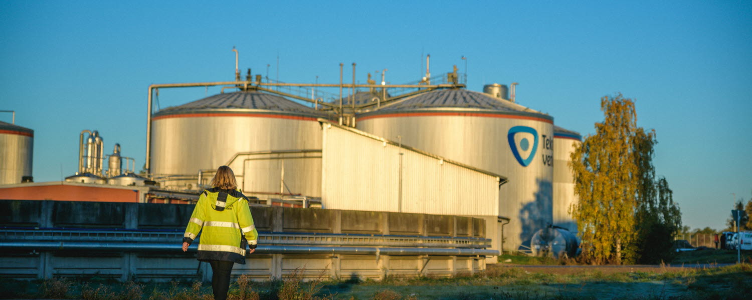 En medarbetare syns i förgrunden framför rötkammare och gödselbrunn