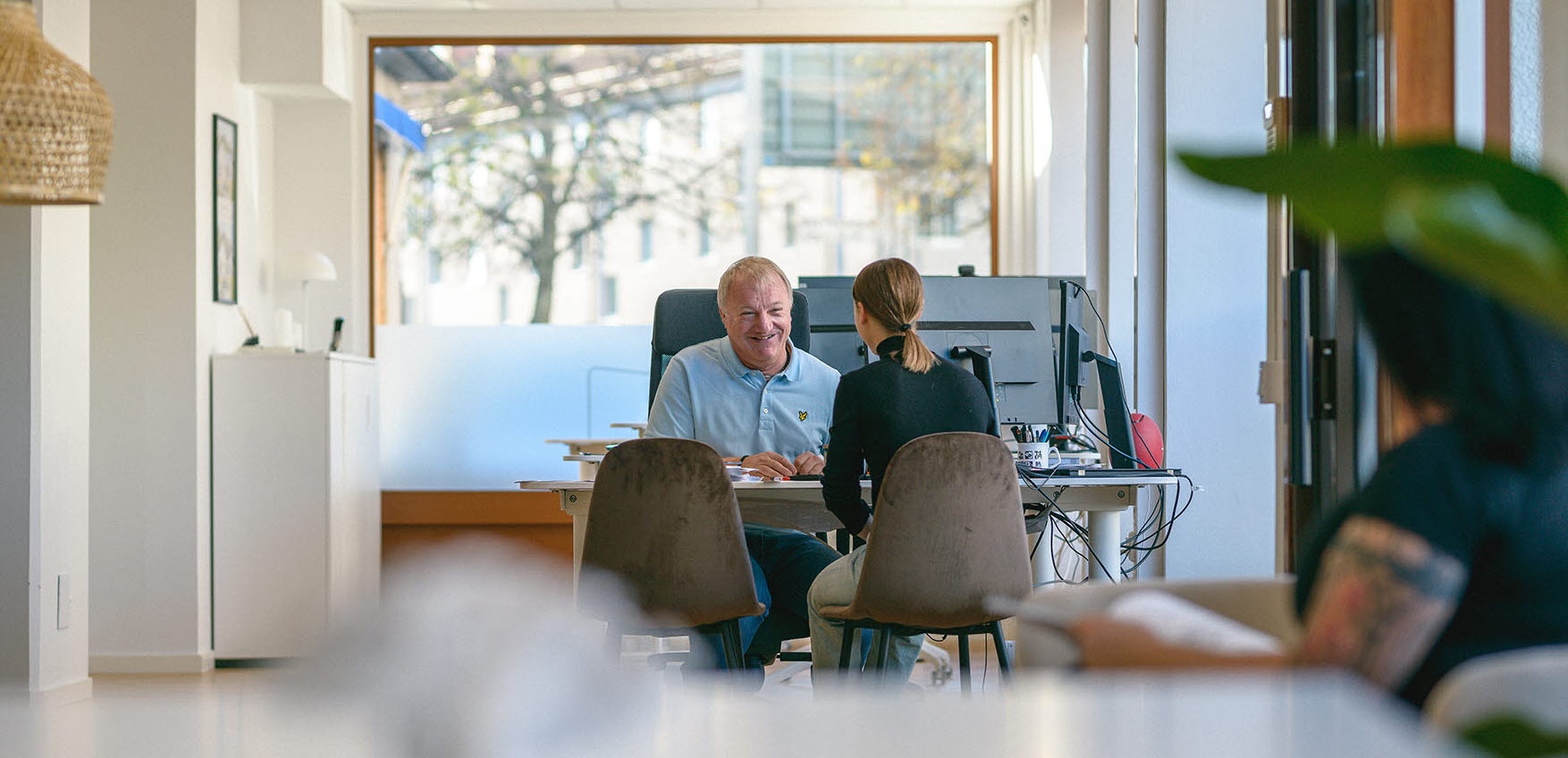 En säljare talar med en kund vid sitt skrivbord